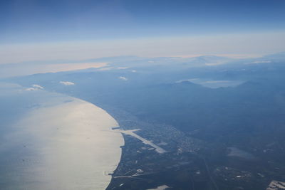 Aerial view of city and mountains against sky