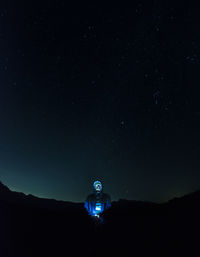 Low angle view of telephone pole against sky at night