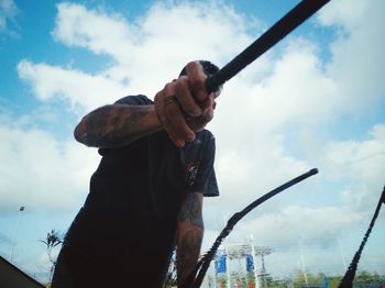 Man holding camera against sky