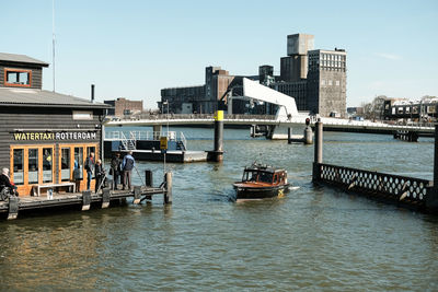 Boats sailing on river in city