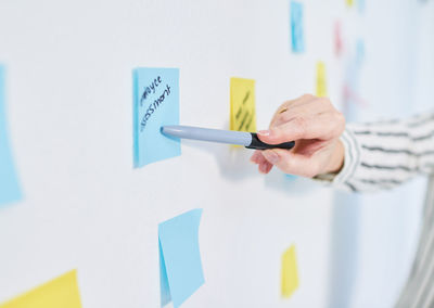 Cropped hand of woman holding paper on table