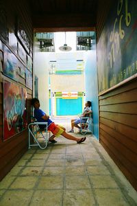 Boy sitting on multi colored corridor