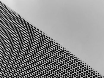 Low angle view of metal grate against sky