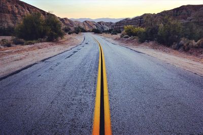 Road by mountain against sky