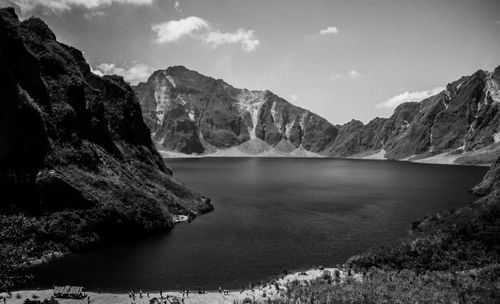 Scenic view of lake by mountains against sky