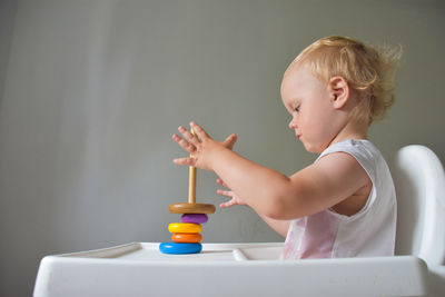 Cute 23 months old baby playing with colorful bricks at home