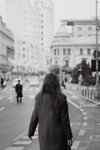 Rear view of woman walking on city street