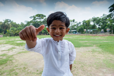 Portrait of smiling boy standing on field