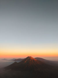 Scenic view of landscape against clear sky during sunset