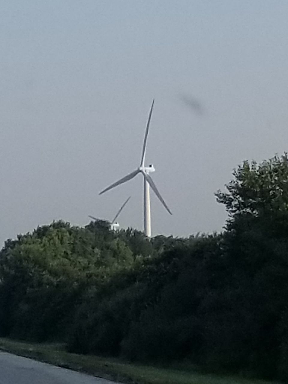 LOW ANGLE VIEW OF WIND TURBINE ON FIELD AGAINST SKY