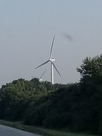 Low angle view of windmill on field against sky