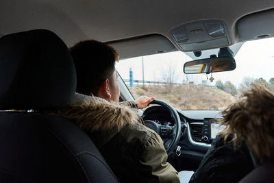 Latin young man drives a car on a snowy day