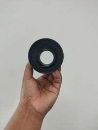 Midsection of person holding camera against white background