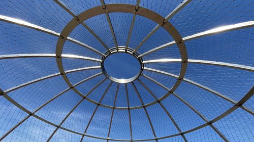 Metal structure forming an overhead cage from low angle view.