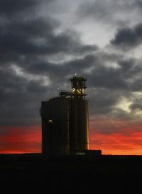 Factory against sky during sunset