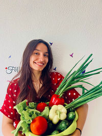 Portrait of smiling young woman with vegetables on table