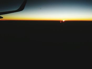 Close-up of silhouette airplane wing against sky during sunset