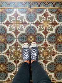 Low section of person standing on tiled floor