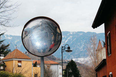 Reflection of trees and buildings on snow covered mountain