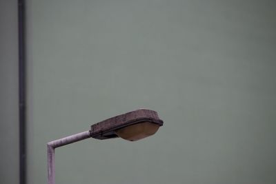 Close-up of street lamp against wall