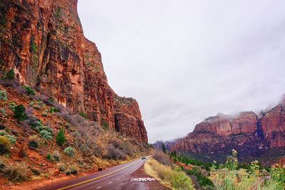 Road leading towards mountains against sky