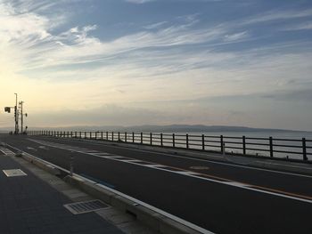 Empty road against sky during sunset