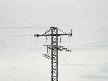 Low angle view of electricity pylon against sky