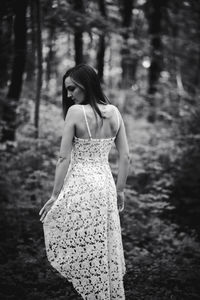 Low section of woman standing in forest