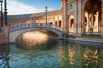 Arches bridge over water outside historic building 