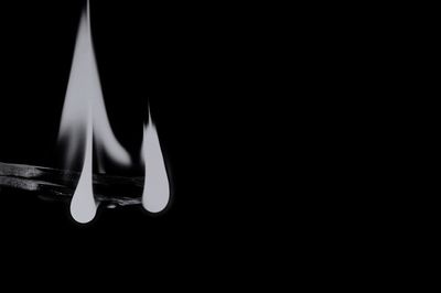 Close-up of illuminated candle in darkroom