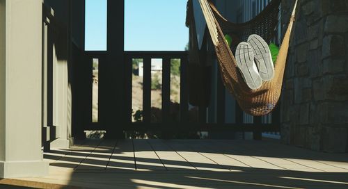 Low section of person relaxing in hammock on porch