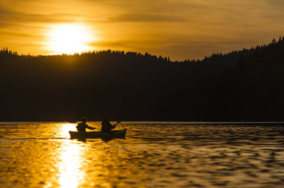 Silhouette of boat in sea at sunset