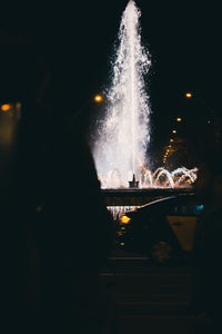 Illuminated firework display at night