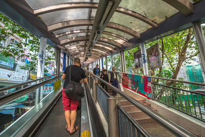 Rear view of woman walking on footbridge