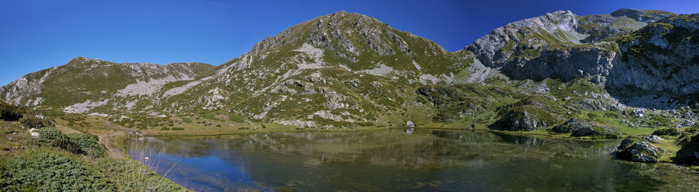 Scenic view of lake by mountain against sky