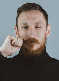 Portrait of smiling handsome bearded man. confident brutal hipster guy with red beard and mustache.