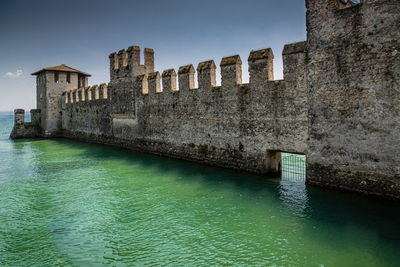 View of canal by building against sky