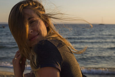 Portrait of woman at beach against sky