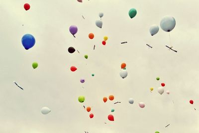 Low angle view of balloons flying against sky