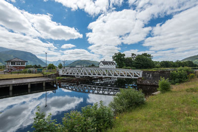 Arch bridge over river against sky