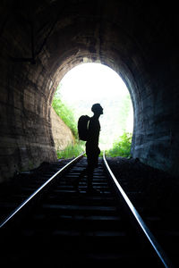 Rear view of man walking in tunnel