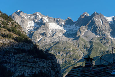 Scenic view of snowcapped mountains against clear blue sky