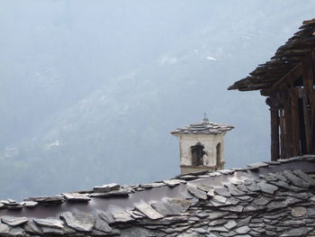 View of building by mountain against sky
