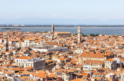 High angle view of townscape by sea against sky