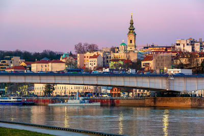 Bridge over river in city against sky