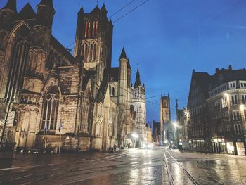 Illuminated clock tower in city at night