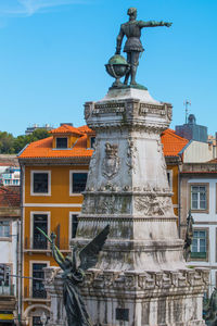 Low angle view of statue against building in city