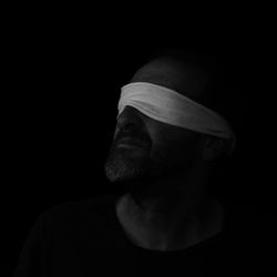 Portrait of man wearing hat against black background