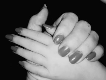 Close-up of human hand holding hair over white background