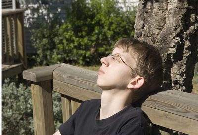 Teenage boy napping on bench at park